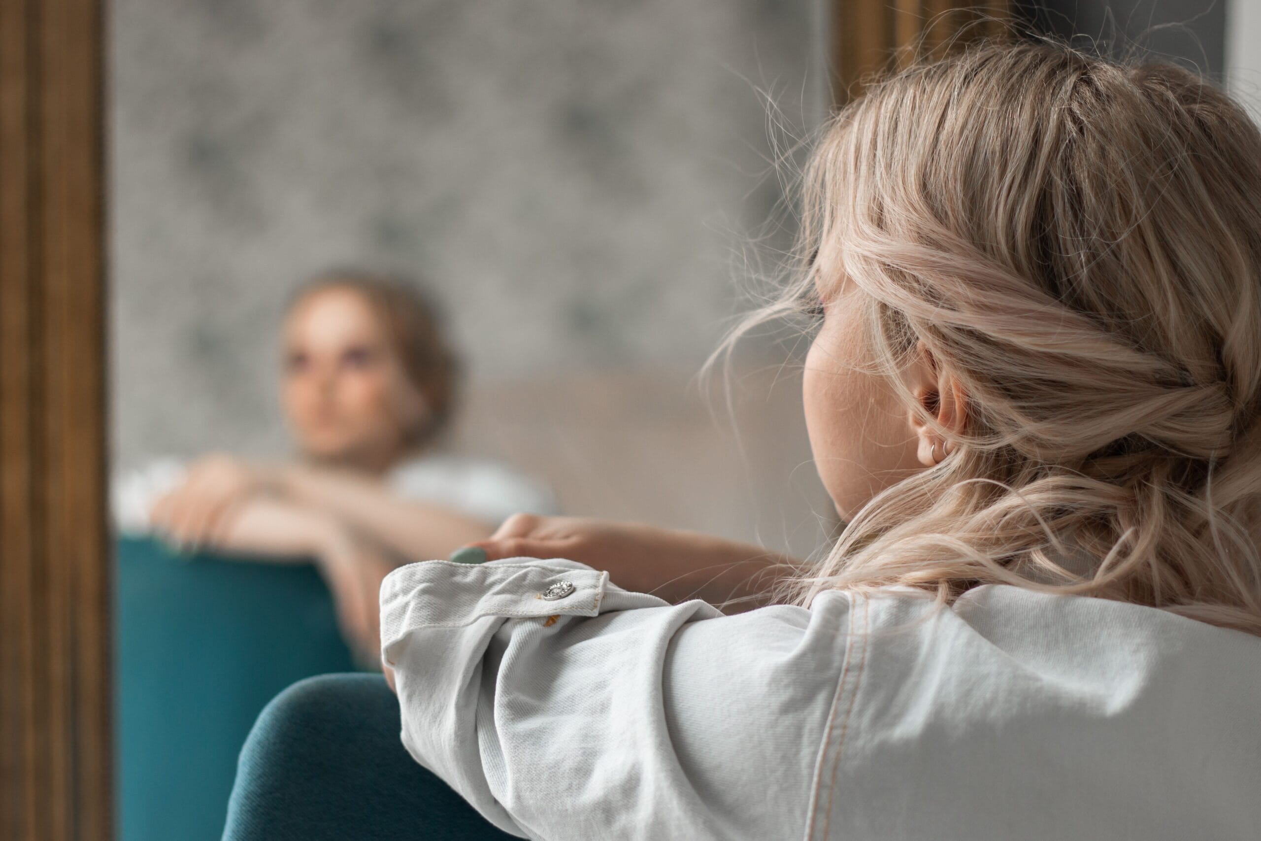 young woman and her reflection looking off into the distance
