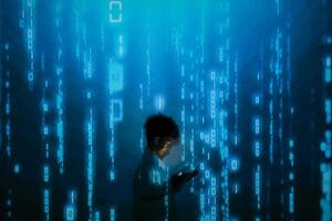 woman looking down at computer against a backdrop of computer code raining down
