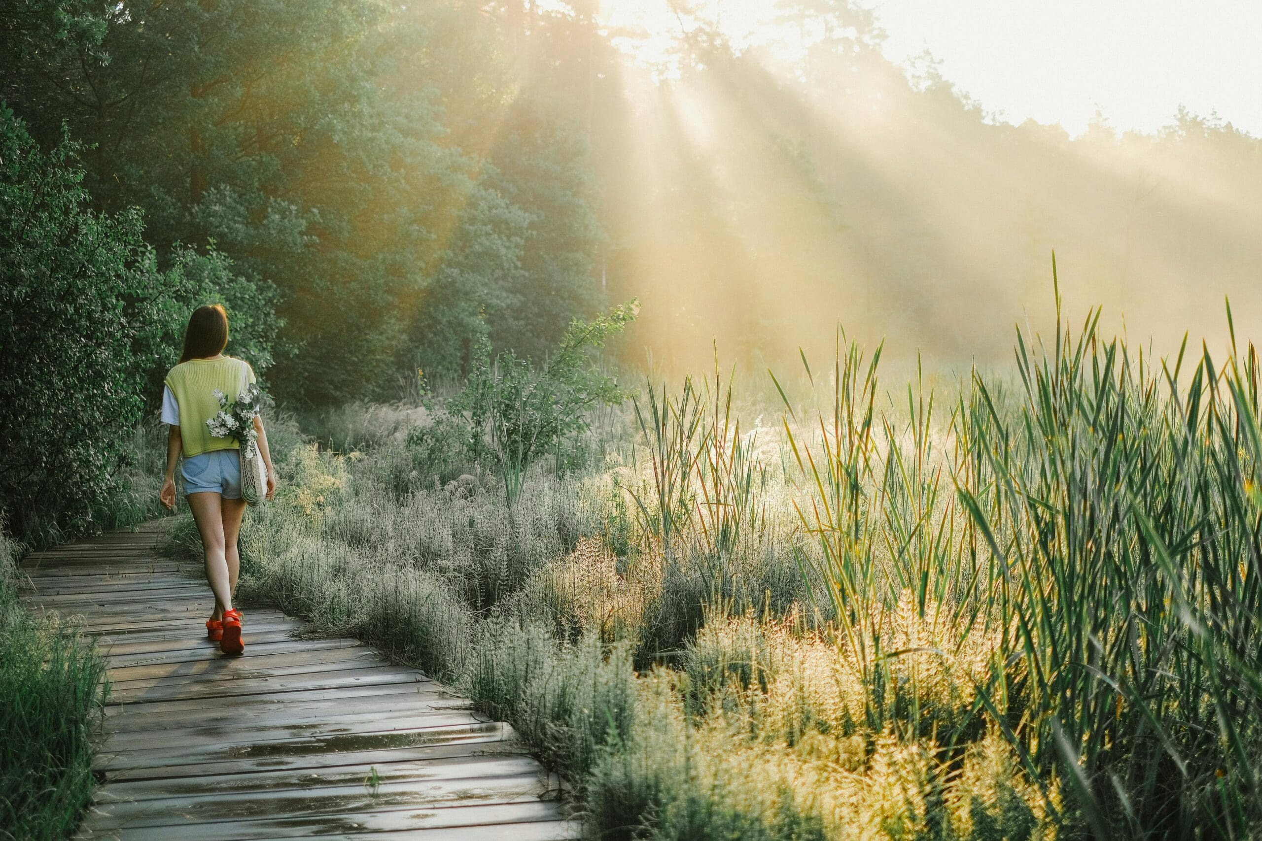 Woman walking down a sunlit path