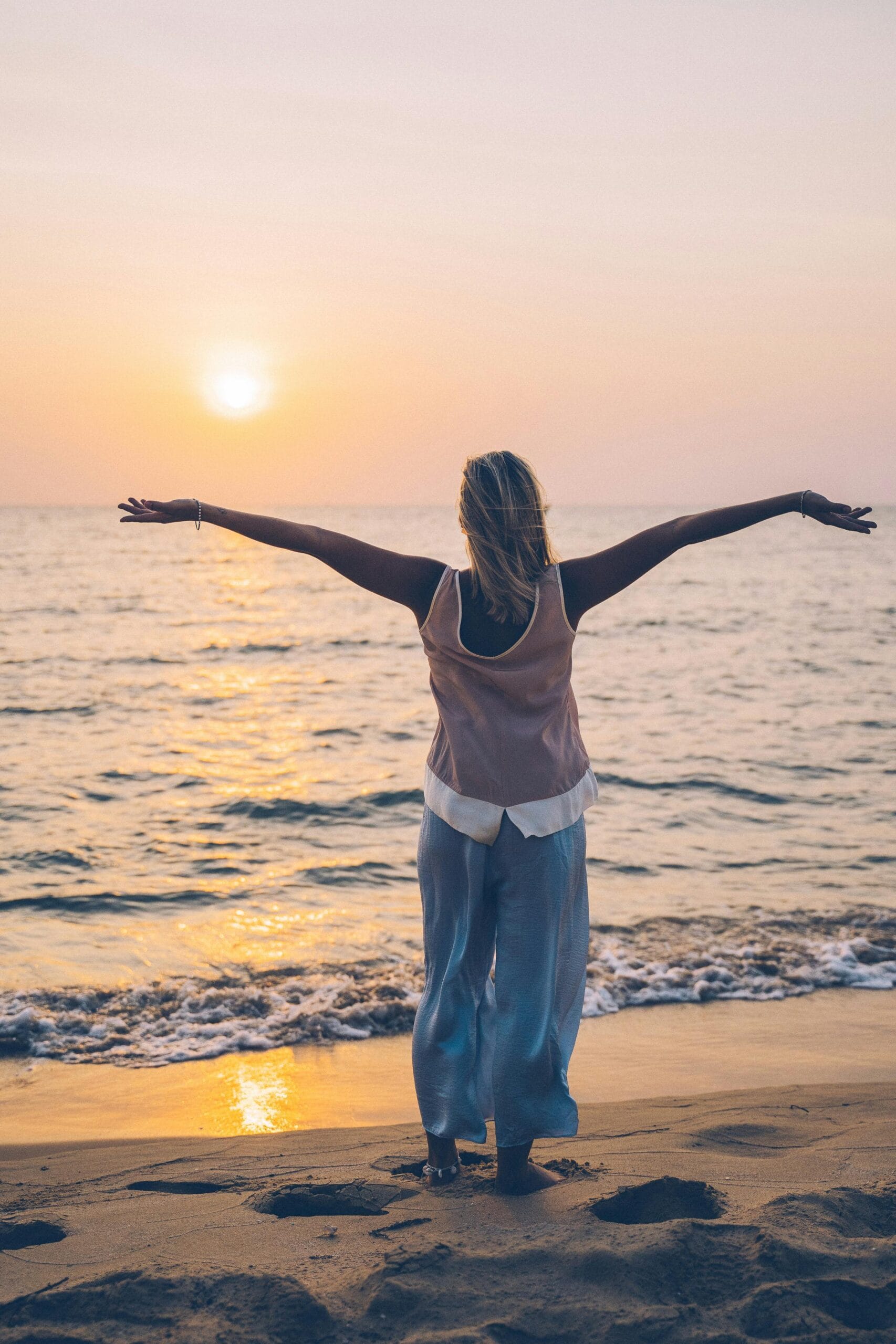 woman with arms open to the ocean